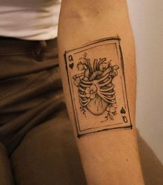 a tattoo on the arm of a person with a heart and flowers in it's center