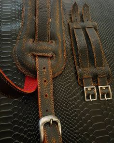 a close up of a black and brown bag with metal buckles on the handle