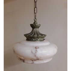 a white marble light hanging from a chain