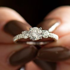 a person holding a diamond ring in their hand