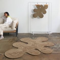 a woman sitting in a chair next to a rug