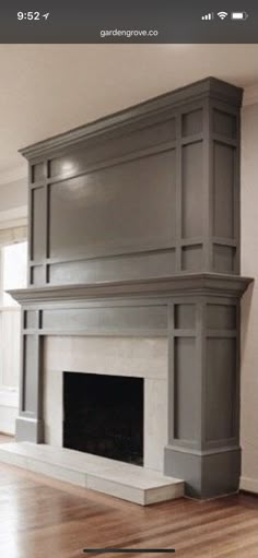 an empty living room with a fireplace and hardwood floors