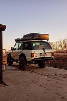 an suv parked in front of a building with a roof rack on it's roof