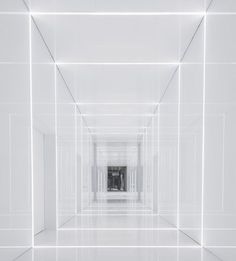 an empty room with white walls and light coming in from the center to the floor