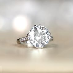 a white diamond ring with diamonds on the sides and an oval shaped center stone in the middle