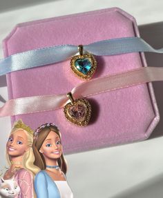 the princess and her cat are in their pink gift box, which is decorated with two heart shaped pendants