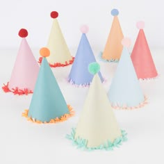 paper party hats with pom poms on them