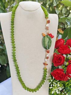 Necklace made with 14 mm hand-knotted green peridot hard stones, prickly pear in Caltagirone ceramic made and painted by hand, with 22 kt gold leaf applications, 6 cm size, white pearls and Mediterranean red coral, length 70 cm. Green Gemstone Beaded Necklaces As Gift, Green Jade Beaded Necklaces As Gift, Green Gemstone Necklaces With Round Beads, Green Gemstone Beaded Necklaces For Gifts, Green Beaded Necklaces With Natural Stones For Gifts, Green Gemstone Beaded Necklace For Gift, Green Polished Beaded Necklace For Gift, Green Gemstone Beaded Necklaces, Unique Green Jewelry With Polished Beads