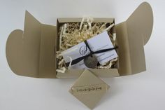 an open box with some items in it on a white surface, and a tag attached to the lid