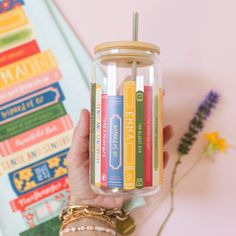 a person holding a jar filled with books