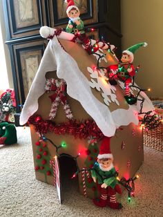 an elaborate gingerbread house decorated with elfs and candy canes