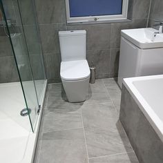 a white toilet sitting next to a walk in shower