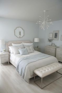 a bedroom with white furniture and light blue walls