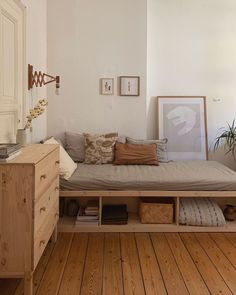 a bed sitting on top of a wooden floor next to a dresser