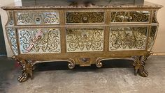 an ornately decorated gold and silver dresser