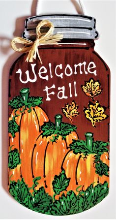 a wooden sign that says welcome fall with pumpkins on the front and green leaves on the back