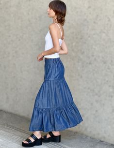 Ultra-light, ultra-soft, ultra-flowy, and ultra cute! The Flounce Denim Maxi Skirt from Billy T, with layered, pleated construction in a fun-and-flattering cut. The cover model is 5'7" wearing size small Fabric: 100% Tencel Length: 35" from waistband to longest point Blue Voluminous Maxi Skirt For Summer, Spring Blue Voluminous Skirt, Relaxed Fit Gathered Skirt For Spring, Non-stretch Gathered Skirt For Spring, High Waist Gathered Skirt For Spring, Spring Denim Tiered Ruffled Skirt, Casual Stretch Tiered Maxi Skirt, Casual Tiered Maxi Skirt With Gathered Detail, Spring Ruffled Tiered Denim Skirt