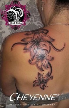 the back of a woman's shoulder with a flower tattoo on her left arm