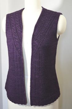 a white mannequin wearing a purple knitted vest