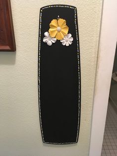 a black board with yellow and white flowers on it