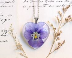 a heart shaped glass necklace with a flower inside