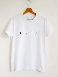 Nope t-shirt. Please refer to our size chart in the thumbnails for exact dimensions. Customisation: If you want a custom shirt with your text or drawing, please contact us. In case you have any questions, just drop us a line and we will give you 110% of our support. Product information: The sleeves are rolled up for display purposes only. In photos you see Unisex style T-shirt. Women's style T-shirts are more fitted. 100% Cotton Preshrunk Jersey knit Reinforcing tape on neck Rib collar Short sle T Shirt Slogans, Sassy Shirts, Minimalist Shirts, Slogan Tshirt, Shirts Women Fashion, Shirt Print Design, Slogan Tee, Tee Shirt Designs, Custom Shirt