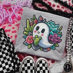 a bag with a skull and flowers on it next to some other items that include shoes