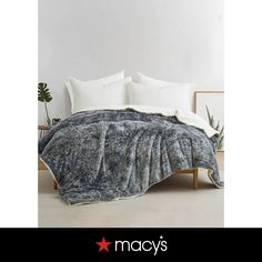 an image of a bed that is made with grey and white fur on the cover