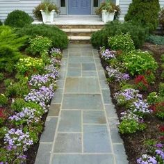 a stone walkway leads to a front door