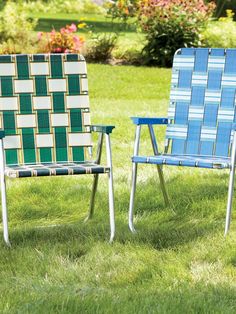 two lawn chairs sitting in the grass near each other