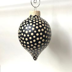 a black and white polka dot ornament hanging from a hook on a wall