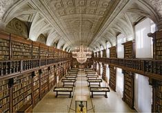 an old library with many bookshelves and chandelier hanging from the ceiling