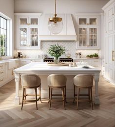 a large white kitchen with two stools at the center and an island in the middle