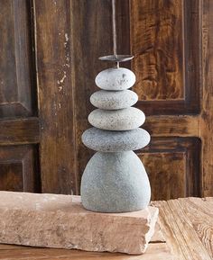 a stack of rocks sitting on top of a wooden table next to a door with a hook in the middle