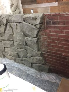 a wall made out of large rocks next to a brick wall in a room that is being remodeled