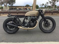 a tan and black motorcycle parked on the street