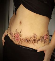 a woman is showing off her stomach with flowers on the side and in the belly