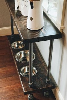 a wooden shelf with three bowls on it and a water dispenser next to it