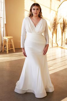 a woman in a white wedding dress posing for a photo with her hands on her hips