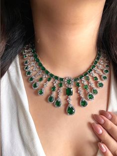 Add a touch of glamour and sophistication with this high quality necklace set in beautiful  emerald green stones. The stones in this set bling and look close to the real thing. This set is sure to make heads turn!  It features an adjustable necklace and a pair of earrings. It can be paired perfectly with both ethnic and western outfits.  In case of any queries, please feel free to reach out. Happy shopping! Item includes Necklace, earrings and maangtika Measurements:  Necklace length: 16 inches (adjustable length with silver colour metal chain) Earrings length: 2" Each earring weighs: 12 gms Emerald Green Stone, Green Stones, Choker Set, Wedding Bridal Jewellery, Silver Colour, Necklace Choker, American Diamond, Adjustable Necklace, Chain Earrings