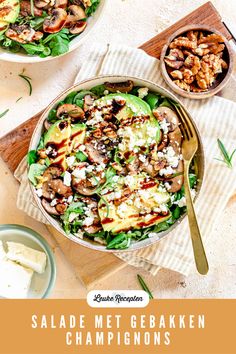 two bowls filled with salad on top of a wooden cutting board next to silverware