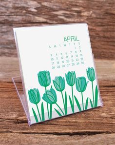 a desk calendar sitting on top of a wooden table