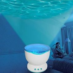 a woman is sitting on a bed in front of an underwater room with blue water