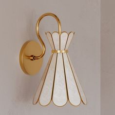 a wall light that is on the side of a wall with a gold handle and glass shades