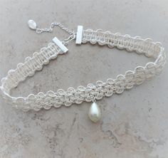 "A braided rayon ivory trim is accented with a wire wrapped tear drop pearl bead.   Braid is crimped and linked with a silver extension chain with a wire wrapped silver bead dangle. The choker closes at 13 1/2\" on first link and the extension chain allows adjustable sizing to 15 1/2\". There is a silver hook closure for adjustable length. if you need a different length, just send a message with your order. All of my jewelry items come boxed and ribbon tied and tagged for easy gifting.  This cho Adjustable Cream Choker, Adjustable Cream Pearl Jewelry, Handmade Adjustable Cream Pearl Necklace, Adjustable Handmade Cream Pearl Necklace, Adjustable Cream Pearl Necklace Gift, Adjustable Cream Pearl Necklace For Gift, Adjustable Cream Pearl Necklace, Adjustable Cream Beaded Pearl Necklace, Bead Choker Necklace