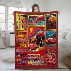 a woman holding up a blanket with cars on it