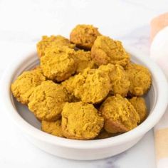 a white bowl filled with pumpkin cookies on top of a table