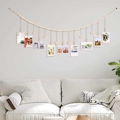 a living room with a white couch and pictures hanging on the wall next to a coffee table