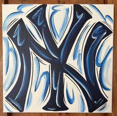 a painting of the new york yankees logo on a wooden surface with blue and white swirls