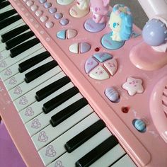 a pink toy piano with many different items on it